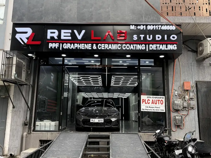 Shopfront board reading Rev Lab Studio, PPF, graphene and ceramic coating, detailing, above the open bay