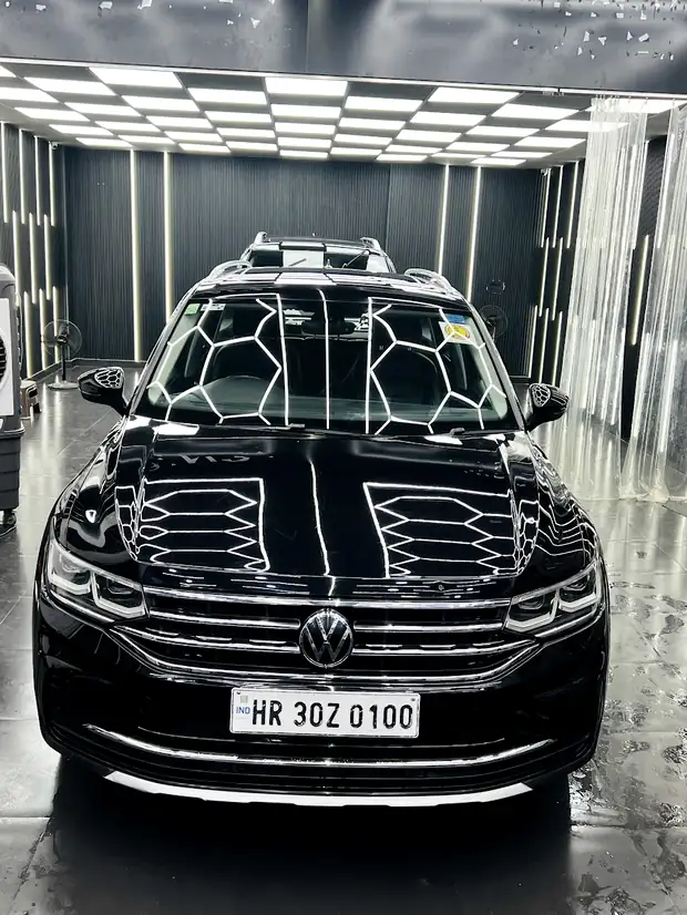 A dark SUV under the hexagon section of the ceiling array